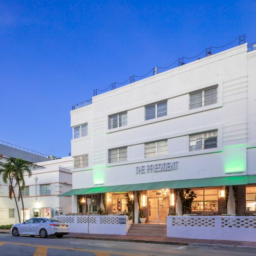 A white, multi-story Art Deco building labeled 